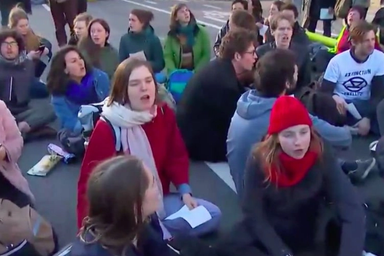 Samen met zo'n 300 andere betogers bezetten Anuna De Wever en Francesca Vanthielen de Wetstraat voor nieuwe kilmaatwet